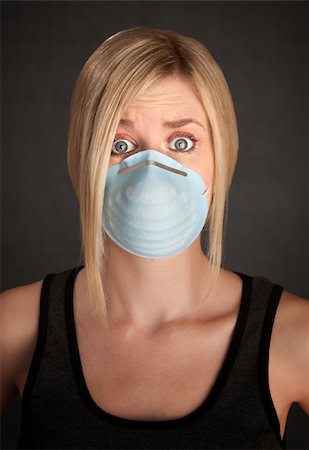 Worried young blonde woman with surgical mask on a grey background Stock Photo - Budget Royalty-Free & Subscription, Code: 400-04831197