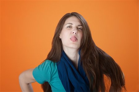 spit - Cute Caucasian girl dressed in blue sticks her tongue out Photographie de stock - Aubaine LD & Abonnement, Code: 400-04831236