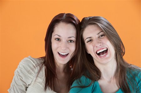 simsearch:400-05347604,k - Two girlfriends on an orange background laugh Stockbilder - Microstock & Abonnement, Bildnummer: 400-04831244