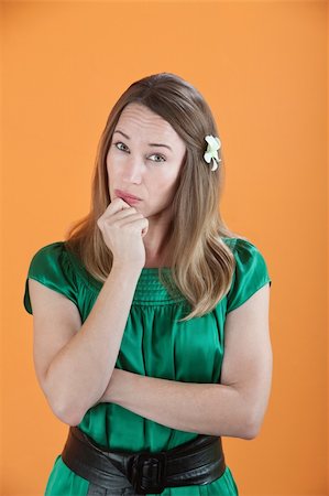 Beautiful Caucasian woman in deep thoughts on an orange background Stock Photo - Budget Royalty-Free & Subscription, Code: 400-04831247