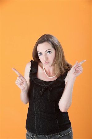 pursed - Beautiful Caucasian woman pointing her index fingers in opposite directions Stock Photo - Budget Royalty-Free & Subscription, Code: 400-04831266
