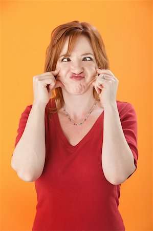 simsearch:400-04382028,k - Cross-eyed, funny-faced Caucasian woman on orange background Photographie de stock - Aubaine LD & Abonnement, Code: 400-04831277