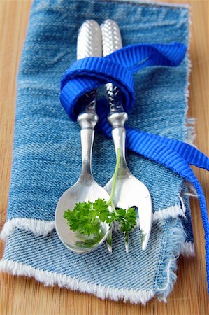 simsearch:400-05355610,k - Spoon and fork in textilein  blue  napkin with a sprig of parsley Photographie de stock - Aubaine LD & Abonnement, Code: 400-04832295