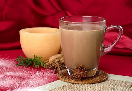 Hot chocolate in glass cup with anise, powder sugar, evergreen branch and candle in the background (Selective Focus, Focus on the glass cup) Stock Photo - Budget Royalty-Free & Subscription, Code: 400-04844588