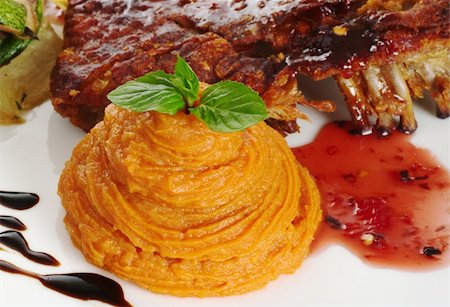 Mashed sweet potato garnished with mint leaf and rib with a red sauce (Selective Focus, Focus on mint leaf as well as top and front of sweet potato puree) Stock Photo - Budget Royalty-Free & Subscription, Code: 400-04844583