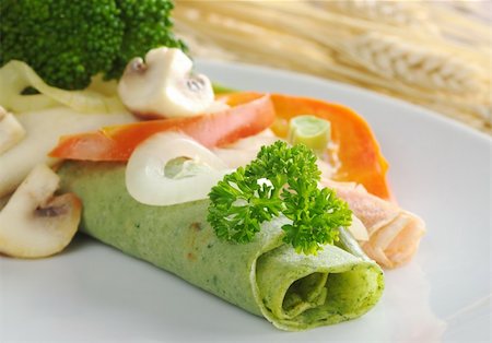 Rolled thin green colored pancake (colored with spinach in dough) with vegetables on top with wheat in the background (Selective Focus, Focus on the parsley and the front side of the pancake) Photographie de stock - Aubaine LD & Abonnement, Code: 400-04844611