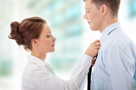 Businesswoman knotting the necktie of the businessman, helping and assisting him getting dressed. Stock Photo - Budget Royalty-Free & Subscription, Code: 400-04844744