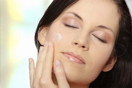Beautiful young woman applying cream on her face. Stock Photo - Budget Royalty-Free & Subscription, Code: 400-04844748