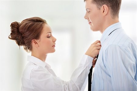Businesswoman knotting the necktie of the businessman, helping and assisting him getting dressed. Stock Photo - Budget Royalty-Free & Subscription, Code: 400-04845110