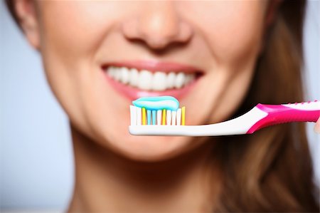 A picture of a toothbrush with toothpaste and a beautiful smile in the background Stock Photo - Budget Royalty-Free & Subscription, Code: 400-04847723