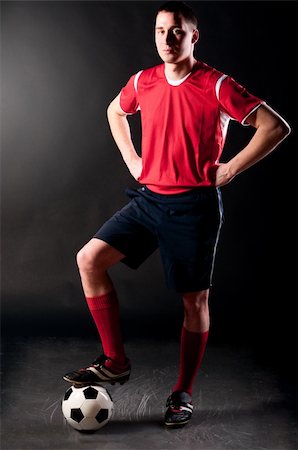 soccer player is standing with ball on dark background Stock Photo - Budget Royalty-Free & Subscription, Code: 400-04849422