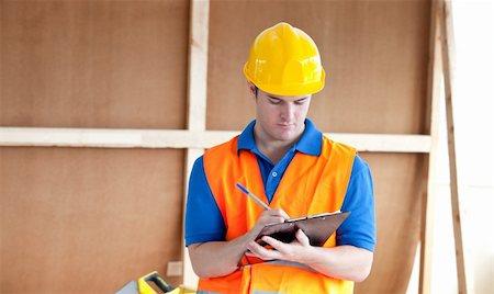 simsearch:400-05714957,k - Self-assured male worker writing on a clipboard at work Stock Photo - Budget Royalty-Free & Subscription, Code: 400-04841230