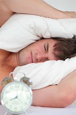 simsearch:400-04287303,k - young male adult stressed by his alarm clock with his head under the pillow in the bedroom Stockbilder - Microstock & Abonnement, Bildnummer: 400-04841246