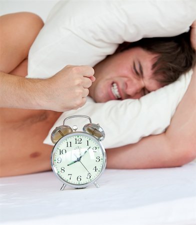 simsearch:400-04287303,k - angry man stressed by his alarm clock lying on his bed at hom Stockbilder - Microstock & Abonnement, Bildnummer: 400-04841247