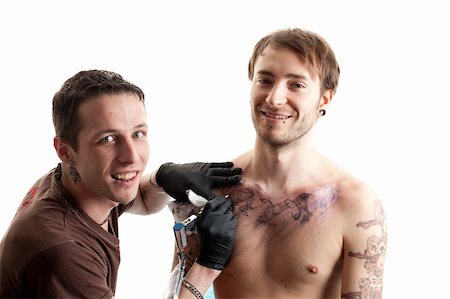 a tattoo artist and his customer during a tattoo session smiling into the camera Fotografie stock - Microstock e Abbonamento, Codice: 400-04842618