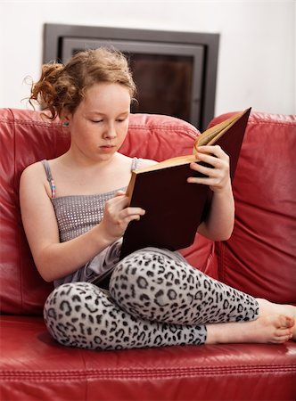 Teenager girl sitting on leather sofa and reading book Photographie de stock - Aubaine LD & Abonnement, Code: 400-04843176