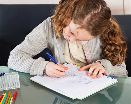 Teenager girl sitting at the table at home and doing her homework Photographie de stock - Aubaine LD & Abonnement, Code: 400-04843171