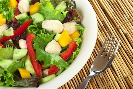 simsearch:400-04854606,k - Fresh chicken salad with lettuce, mango, red bell pepper and cucumber (Selective Focus, Focus on the salad on the right) Foto de stock - Royalty-Free Super Valor e Assinatura, Número: 400-04854606