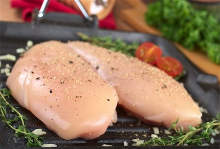 frying chicken in pan - Raw chicken breast in frying pan seasoned with pepper, garlic and thyme (Selective Focus, Focus on the front of the left breast) Stock Photo - Budget Royalty-Free & Subscription, Code: 400-04854602