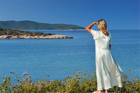 simsearch:400-04718145,k - A blond beautiful woman is gazing at the spectacular view of the Greek islands during a clear morning of her summer holidays Photographie de stock - Aubaine LD & Abonnement, Code: 400-04854861