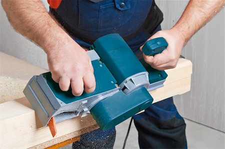 simsearch:400-04856931,k - Close-up of a construction worker's hand and power tool while planing a piece of wood trim for a project. Photographie de stock - Aubaine LD & Abonnement, Code: 400-04857692