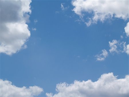 White puffy clouds in a blue sky with copy space. Foto de stock - Super Valor sin royalties y Suscripción, Código: 400-04858241