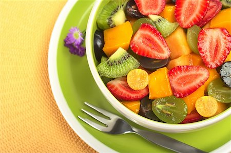 simsearch:400-04859746,k - Fresh and healthy fruit salad with strawberry, kiwi, grape, mango and physalis in a bowl with fork and small blue flowers photographed from above (Selective Focus, Focus from the front to the middle of the bowl) Foto de stock - Super Valor sin royalties y Suscripción, Código: 400-04859745