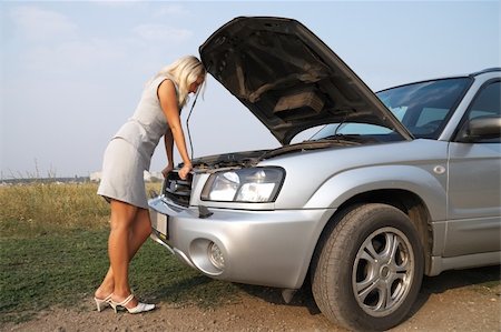 blonde looks blankly under the hood of the broken car Stock Photo - Budget Royalty-Free & Subscription, Code: 400-04850225