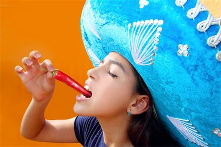 person with hot pepper - Mexican girl profile eating red hot chili pepper mexican hat Stock Photo - Budget Royalty-Free & Subscription, Code: 400-04850772