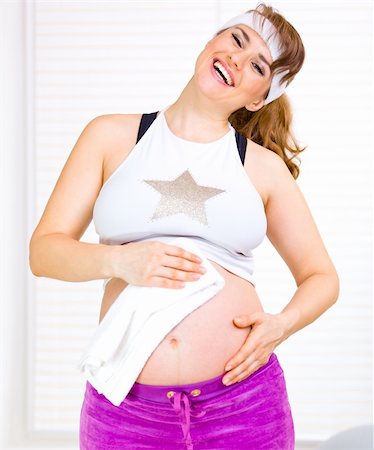 Laughing beautiful pregnant woman wiping her belly with towel after exercising Stock Photo - Budget Royalty-Free & Subscription, Code: 400-04851557