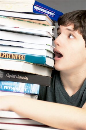 Close-up of a terrified teen looking at a stack of textbooks. Stock Photo - Budget Royalty-Free & Subscription, Code: 400-04851926