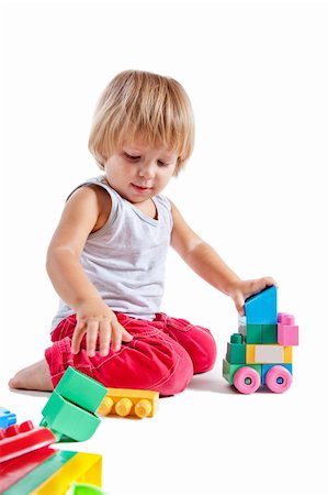 Cute little boy playing with toys, isolated on white background Stock Photo - Budget Royalty-Free & Subscription, Code: 400-04852221