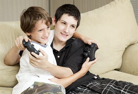 Two affectionate brothers playing video games together. Stock Photo - Budget Royalty-Free & Subscription, Code: 400-04864679