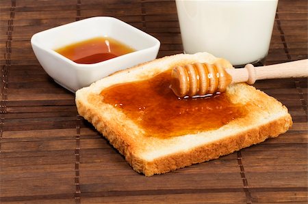 honey with honey dipper on a toast with a glass of milk and a jar with honey Stock Photo - Budget Royalty-Free & Subscription, Code: 400-04865457