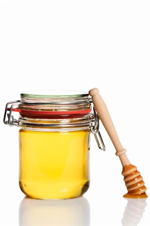 simsearch:400-04865454,k - honey covered honey dipper leaning at a honey jar on white background Stockbilder - Microstock & Abonnement, Bildnummer: 400-04865450