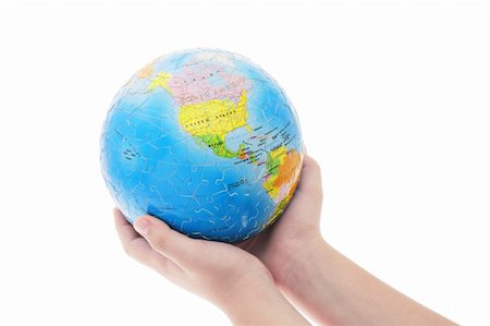 simsearch:400-04865676,k - Young boy's hand holding completed globe jigsaw puzzle on white background Fotografie stock - Microstock e Abbonamento, Codice: 400-04865676