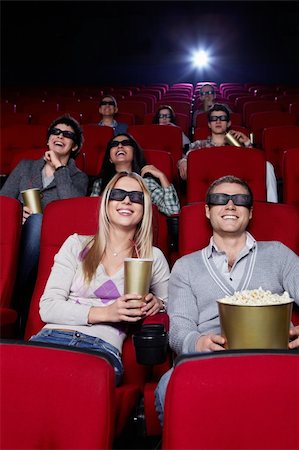 Smiling people in 3D glasses watching a movie at the cinema Stock Photo - Budget Royalty-Free & Subscription, Code: 400-04865869