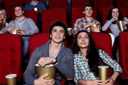 Young people are closely watching a movie at the cinema Stock Photo - Budget Royalty-Free & Subscription, Code: 400-04865872