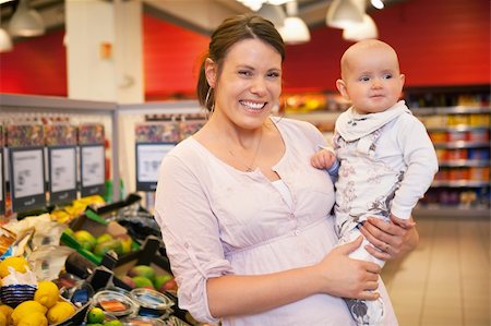 Closeup of a happy mother carrying child in supermarket Stock Photo - Budget Royalty-Free & Subscription, Code: 400-04867826