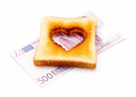 A slice of toast with a heart shape in it, on a banknote Stock Photo - Budget Royalty-Free & Subscription, Code: 400-04867893