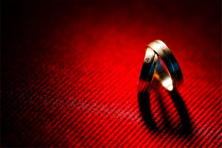 Heart shaped shadow of golden wedding rings with diamond is on red striped velvet Fotografie stock - Microstock e Abbonamento, Codice: 400-04868580