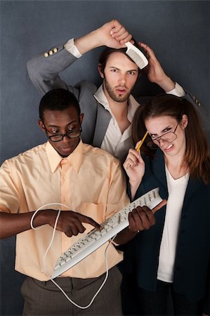 simsearch:400-04382028,k - Two nerds with glasses work on a problem while another man combs his hair Photographie de stock - Aubaine LD & Abonnement, Code: 400-04869541