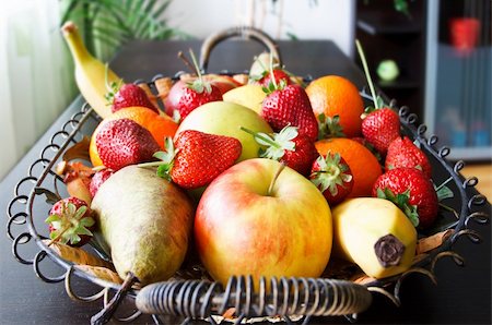 fruits basket in living room with strawberries, apples, pears, oranges, lemon, bananas Foto de stock - Super Valor sin royalties y Suscripción, Código: 400-04869928