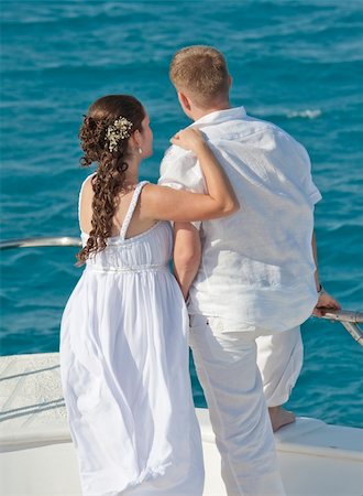 Newly married couple embracing while stood on the bow of a boat Stock Photo - Budget Royalty-Free & Subscription, Code: 400-04860218