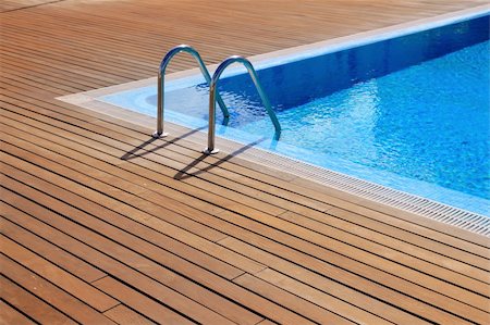 blue swimming pool with teak wood flooring stripes summer vacation Fotografie stock - Microstock e Abbonamento, Codice: 400-04862619