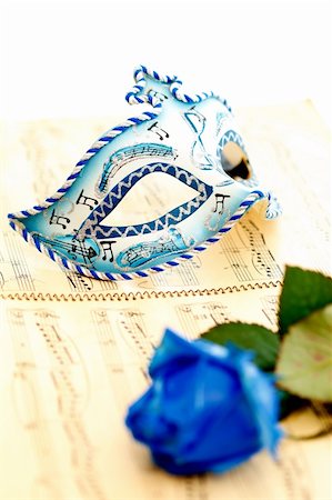 Beautiful carnival mask on a music paper, by a blue rose Stock Photo - Budget Royalty-Free & Subscription, Code: 400-04863434