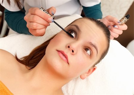 Cosmetician applying mascara for a beautiful young woman Foto de stock - Royalty-Free Super Valor e Assinatura, Número: 400-04863445