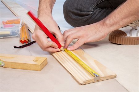 Cropped hand of a carpenter taking measurement of a wooden plank Stock Photo - Budget Royalty-Free & Subscription, Code: 400-04874295