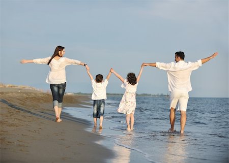 happy young family have fun on beach run and jump  at sunset Stock Photo - Budget Royalty-Free & Subscription, Code: 400-04874436
