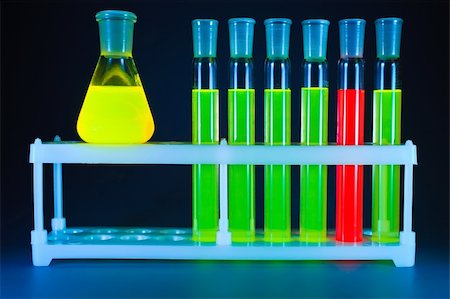 simsearch:649-07279762,k - Five test tubes with a green fluorescing liquid and one with a red liquid in a support and yellow flask on a dark blue background. Stock Photo - Budget Royalty-Free & Subscription, Code: 400-04874911
